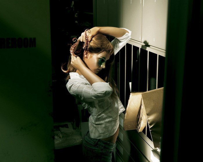 Woman with tentacles in hair in a dark room