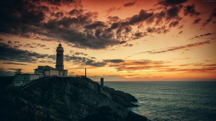 Lighthouse on cliff at sunset 4k