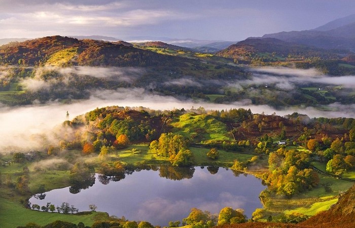 Misty Autumn Morning Over a Lake and Hills