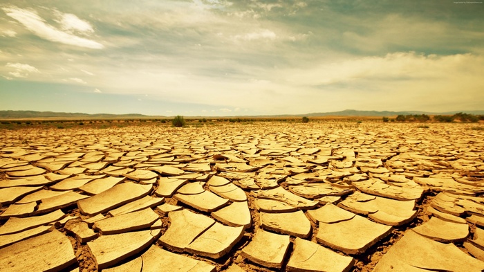 Cracked desert landscape under a cloudy sky