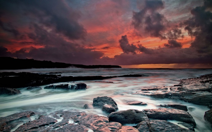 Rocky coastline at sunset with dramatic clouds
