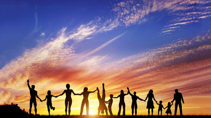 Family holding hands at sunset