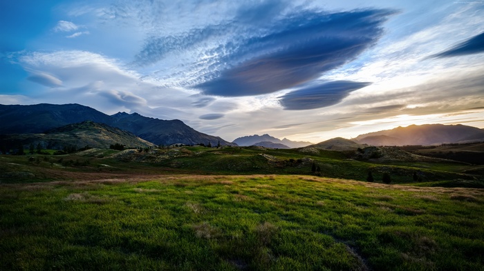 Mountains and clouds over green meadows in New Zealand