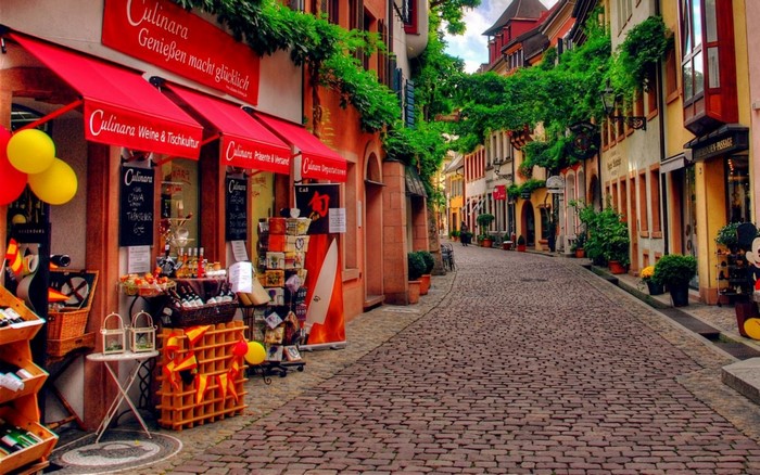 Cobblestone street with shops and greenery in Germany