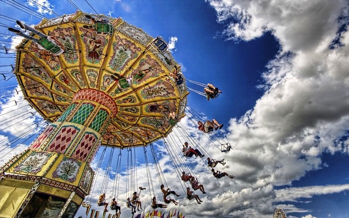 Amusement park swing ride with people on a cloudy day