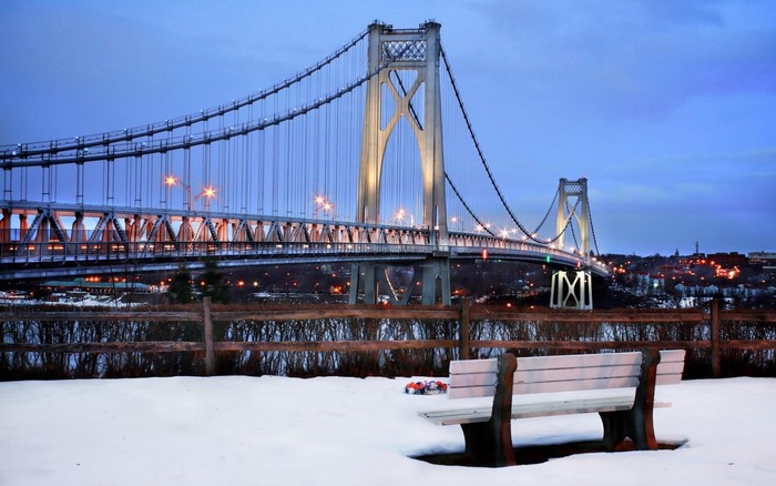Mid Hudson Bridge in winter with snow and a bench
