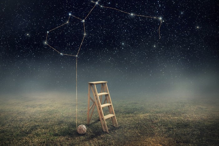 Constellation connected to a ladder on a grassy field under starry sky