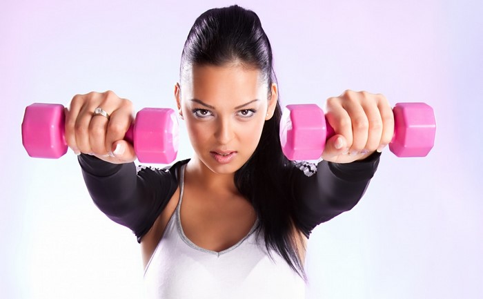 Focused Woman Exercising with Pink Dumbbells