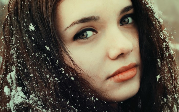 Close up portrait of a young woman with snow in her hair