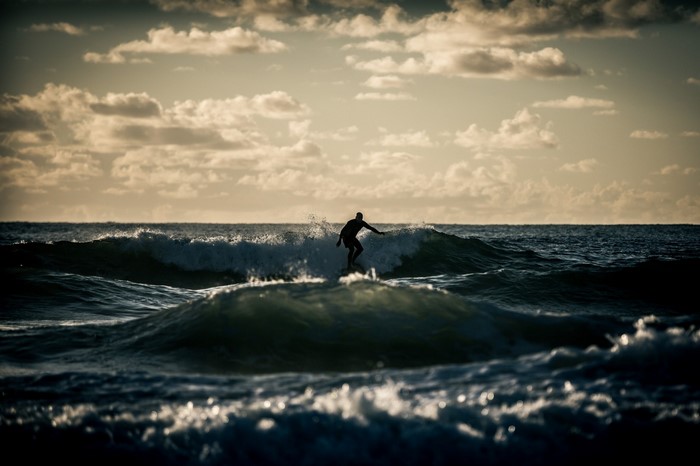Surfer riding a wave at sunset
