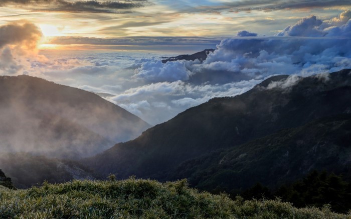 Mountain valley with clouds at sunrise