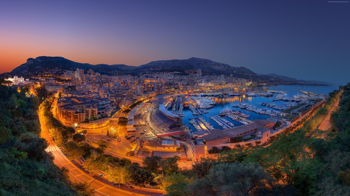 Monaco cityscape and harbor at twilight with boats