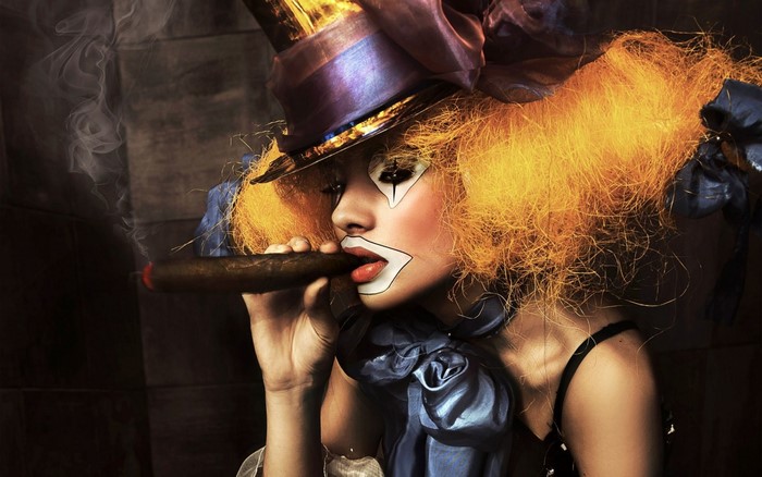 Clown woman with orange hair smoking a cigar