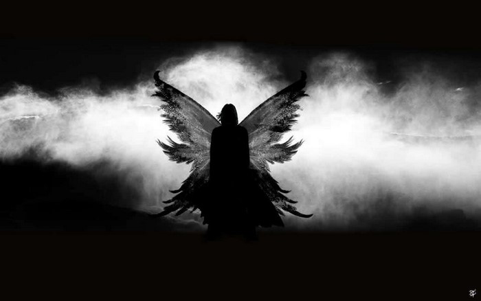 Silhouette of an angel with large wings in smoke
