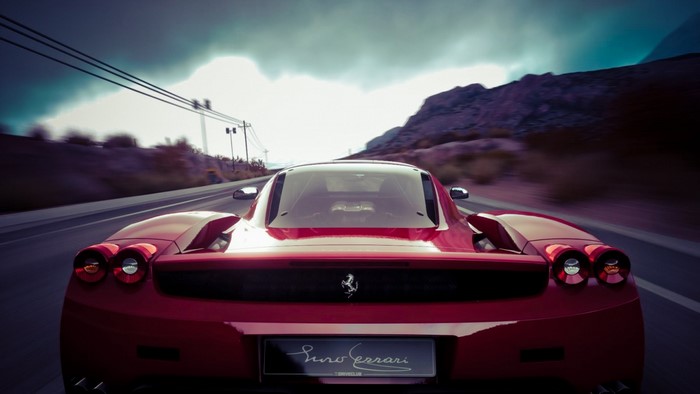 Red Ferrari Enzo driving on a road