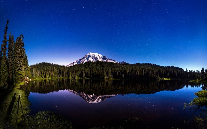 Snow-capped mountain reflected in a lake at night
