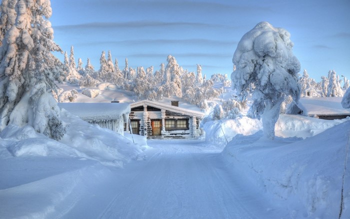 Snow-covered log cabin in a winter landscape