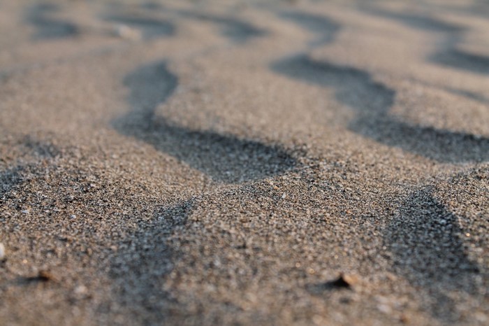 Close-up of sand dunes with sunlight and shadows