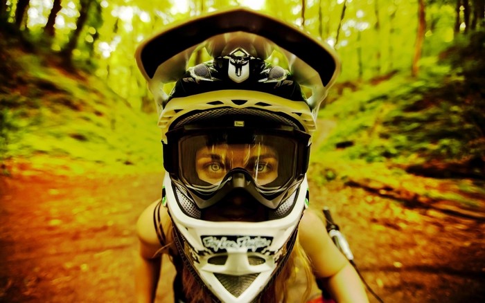 Woman wearing a downhill mountain biking helmet and goggles