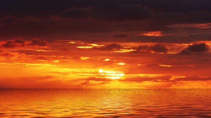 Sunset over the ocean with dramatic clouds