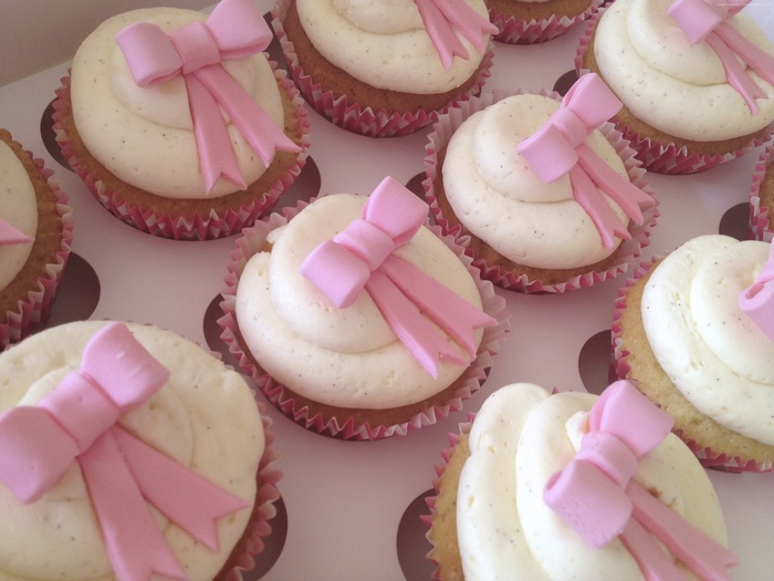 Cupcakes with cream frosting and pink bows