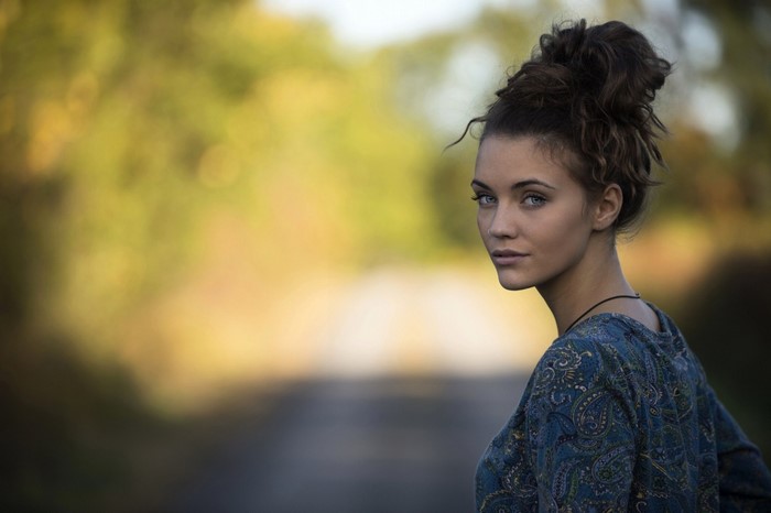Woman with messy bun and blue eyes looking over shoulder