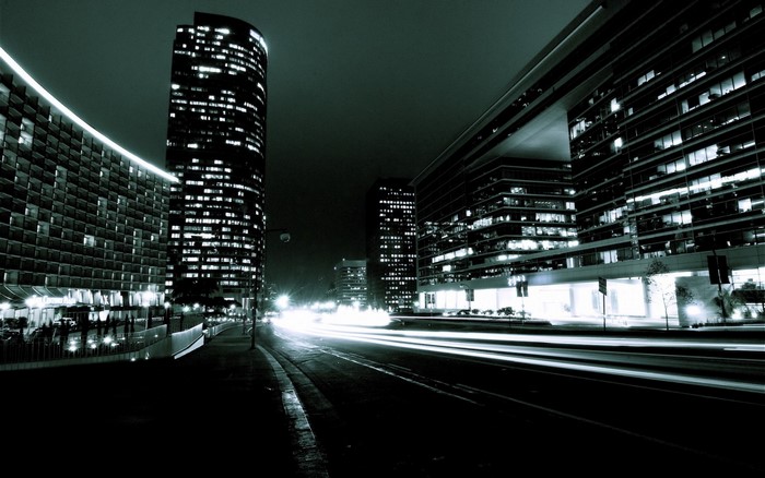 Cityscape at night with light trails and illuminated buildings