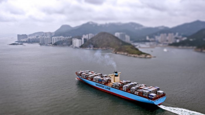 Maersk Line cargo ship sailing in a bay with city and mountains