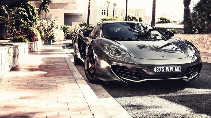 McLaren MP4-12C parked on a street with palm trees