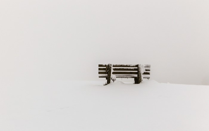 A snow-covered bench in a winter landscape