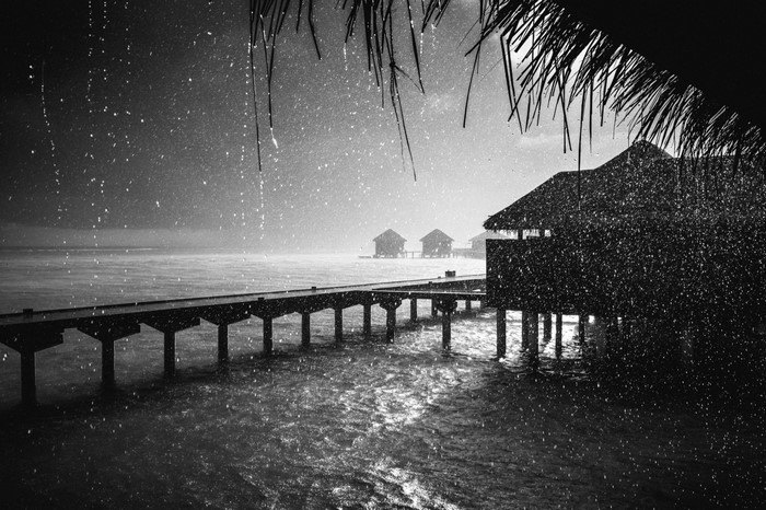 Rainy day over a pier and overwater bungalows in the Maldives