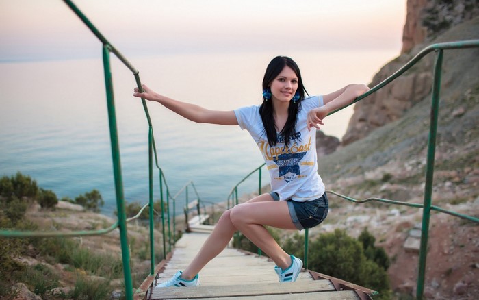 Woman sitting on stairs by the sea