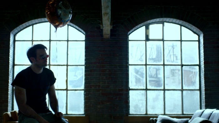 Daredevil from Marvel sitting by a window
