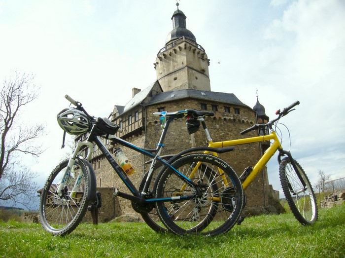 Two mountain bikes in front of a castle