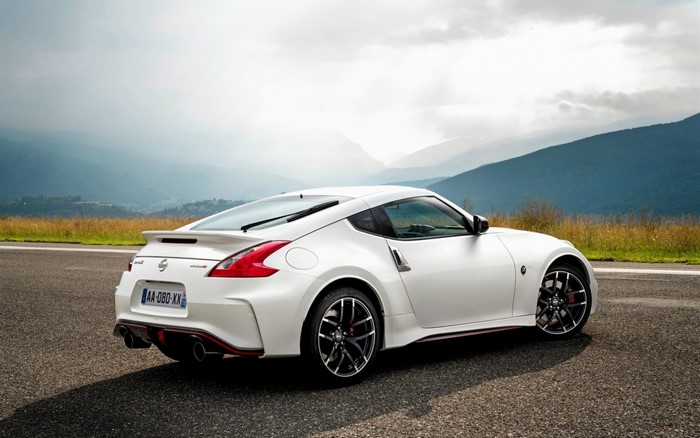 White Nissan 370Z Nismo parked on a road with mountains