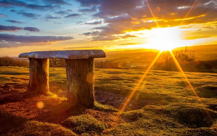 Stone table and bench at sunset overlooking a valley
