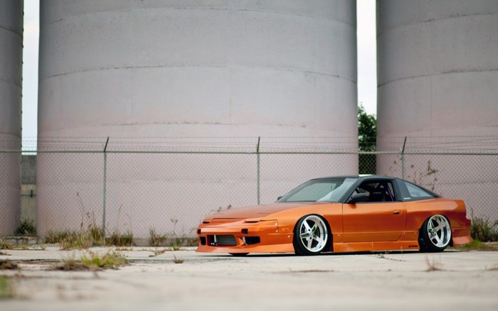 Orange Nissan 240SX sports car with custom wheels