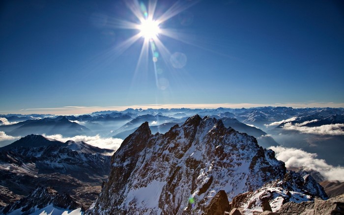 Sunlight over snow-capped mountains and valleys