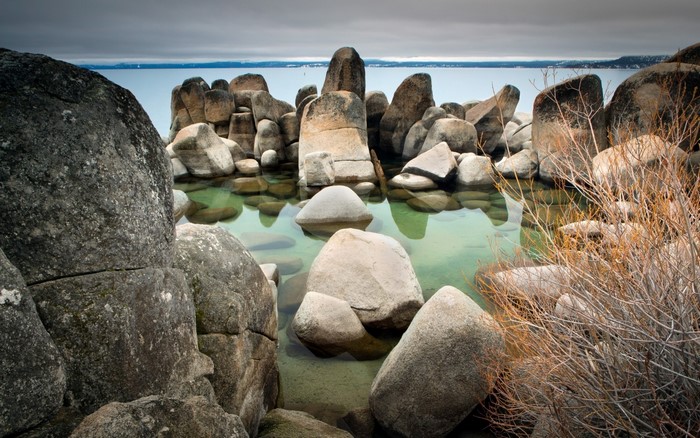Rocky shore with clear water and distant mountains