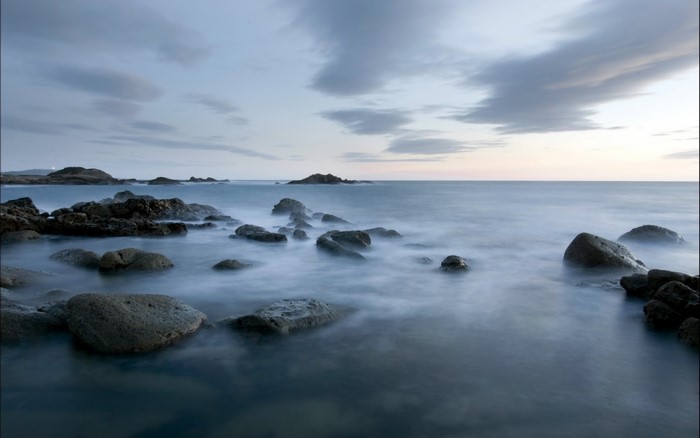 Rocky coast with calm ocean at dusk
