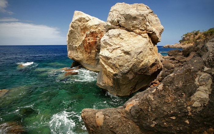 Large boulders on a rocky coast with turquoise sea