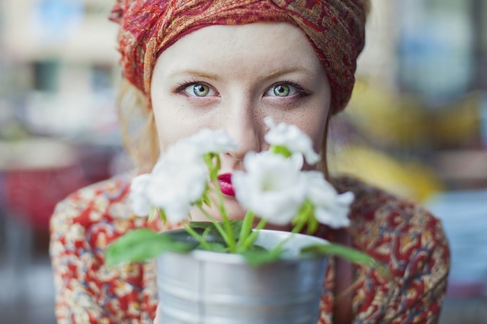 Woman with red headscarf holding white flowers