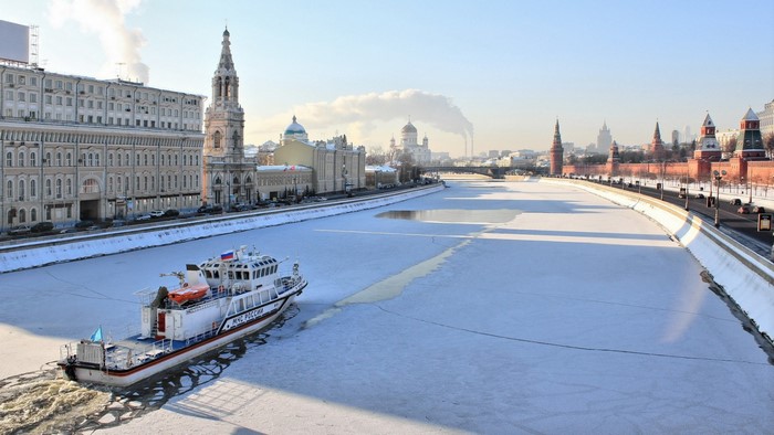 Boat on a frozen river in Moscow with Kremlin in the background