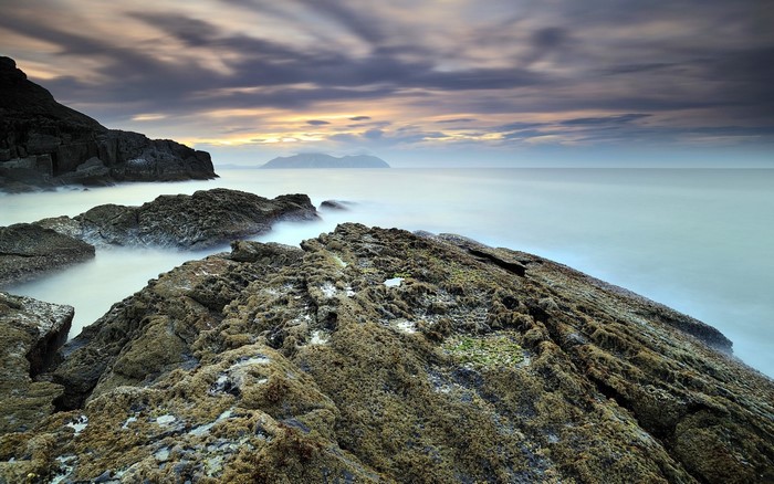 Rocky coast with ocean and clouds at sunset