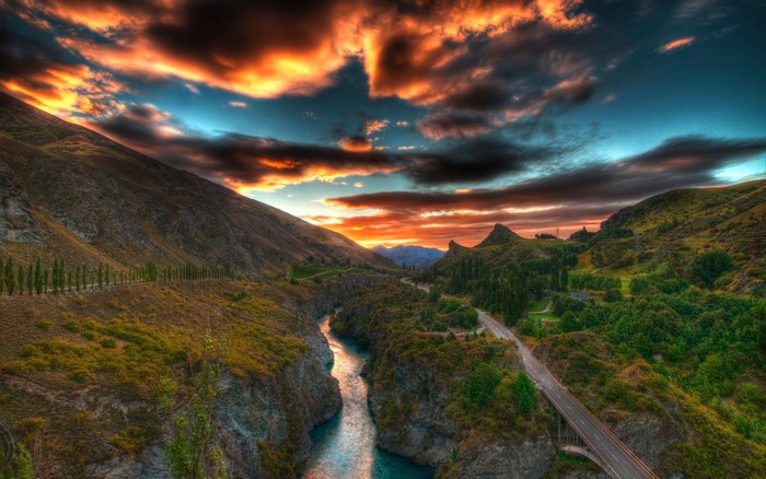 River canyon at sunset with dramatic clouds and mountains
