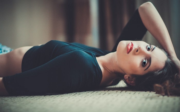 Woman with red lipstick lying on the floor