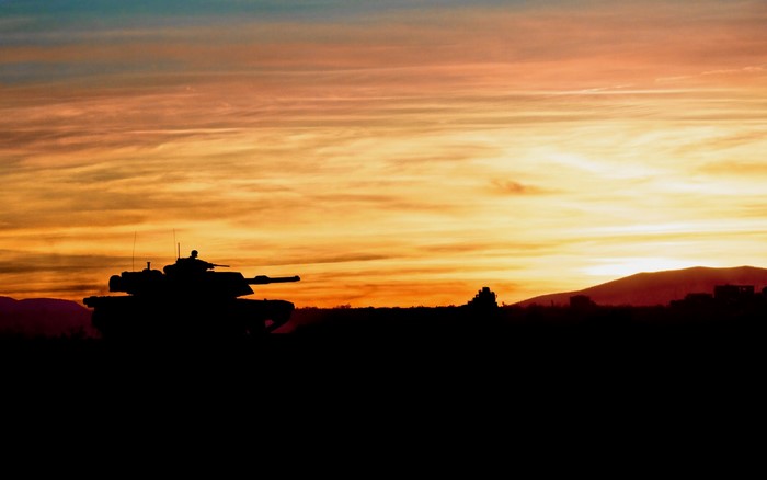 Silhouette of a tank against a sunset sky
