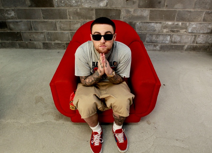 Mac Miller sitting in a red chair