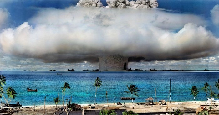 Nuclear explosion over the ocean with ships and palm trees