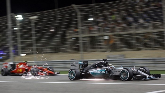 Formula 1 race cars on a track at night